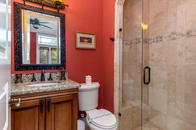 a bathroom with a granite countertop toilet sink and shower