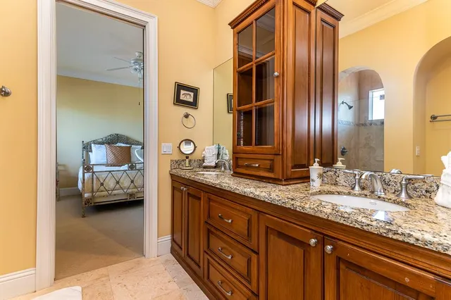 a en suite bathroom with a granite countertop sink and a mirror