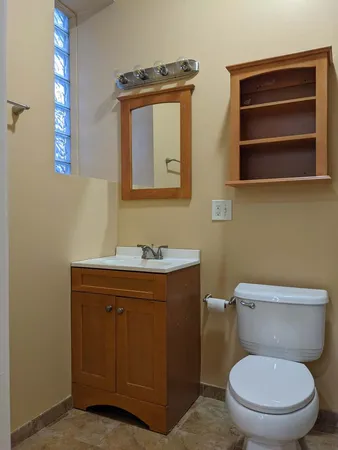 a bathroom with a toilet a sink and mirror