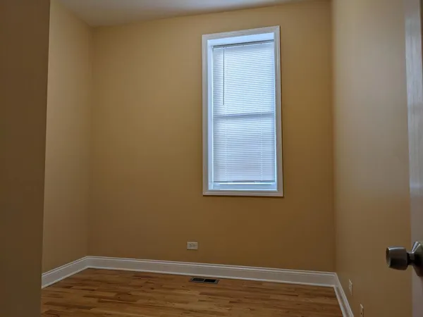 a view of a small space with wooden floor and a window
