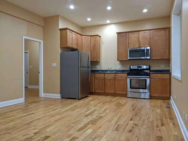 a kitchen with stainless steel appliances granite countertop a refrigerator and a stove