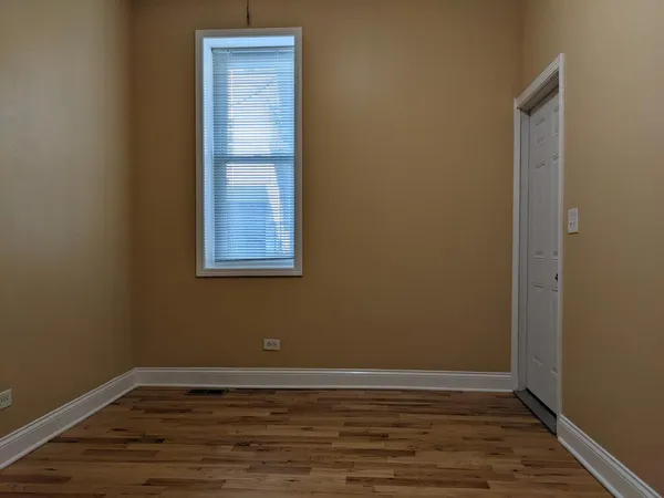 a view of a small space with wooden floor and a window