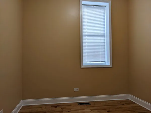 a view of a small space with wooden floor and a window