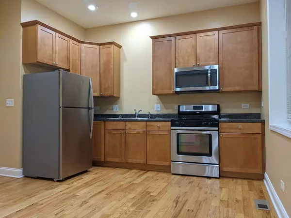 a kitchen with granite countertop a refrigerator stove and microwave