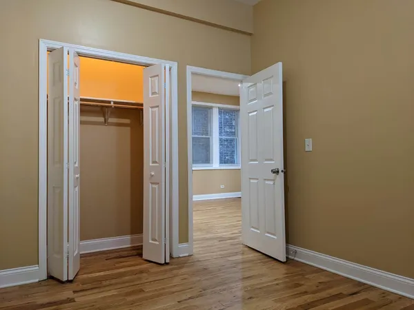 an empty room with wooden floor and a window