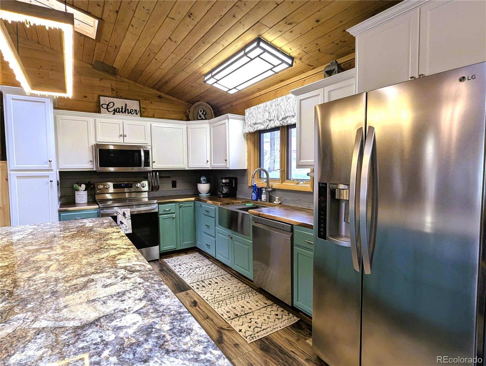 2084 Forbes Park Road Fort Garland, CO 81133 - Photo 22 of 39 a kitchen with stainless steel appliances granite countertop a refrigerator a stove top oven a sink and dishwasher