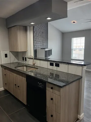 a kitchen with granite countertop a sink a stove and cabinets