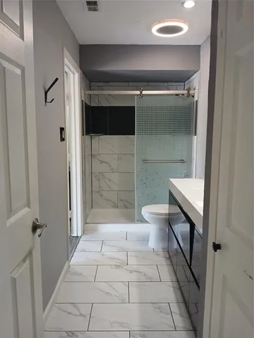 a bathroom with a toilet and a shower