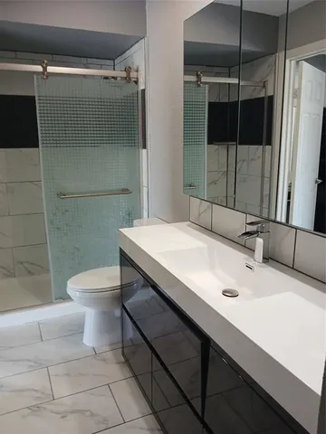 a bathroom with a sink toilet and shower
