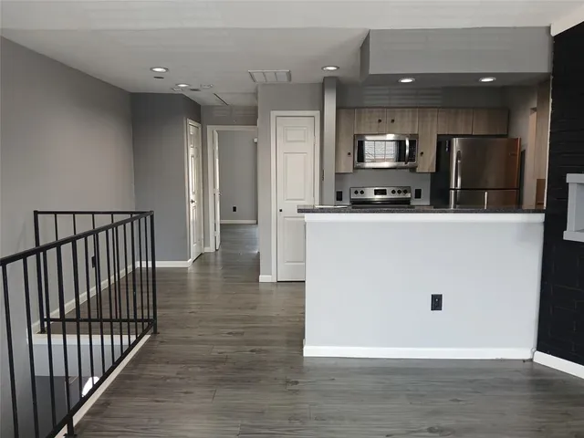 a view of a kitchen with stainless steel appliances wooden floor and a view of kitchen