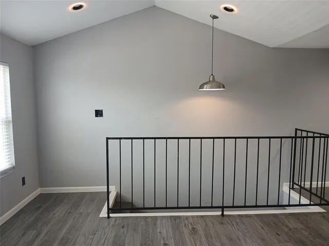 a view of a hallway with wooden floor and a chandelier