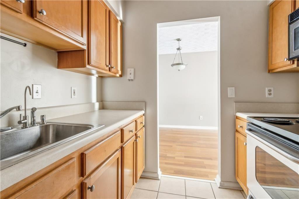3155 Seven Pines, Unit 303 Atlanta, GA 30339 - Photo 11 of 25 a kitchen with stainless steel appliances granite countertop a sink and a stove