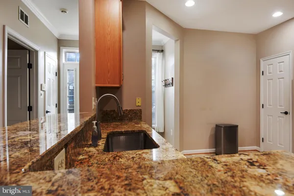 a view of a kitchen with stainless steel appliances granite countertop a refrigerator a stove and a sink