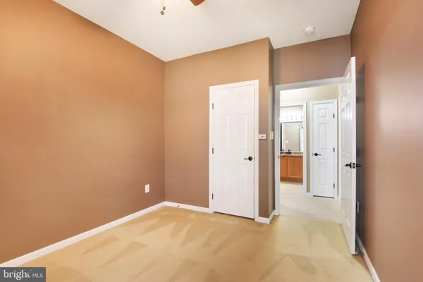 an empty room with a window and a chandelier fan