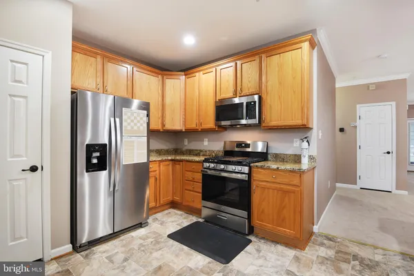 a kitchen with stainless steel appliances granite countertop a stove a sink and a microwave