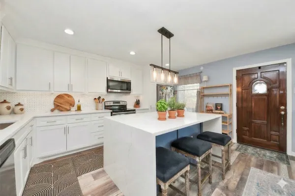 a kitchen with a stove a sink and a microwave