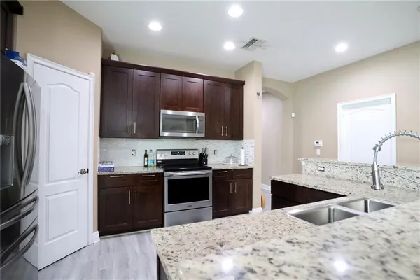 a kitchen with stainless steel appliances granite countertop a sink stove and refrigerator