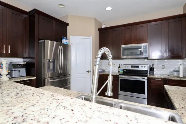 a kitchen with granite countertop wooden cabinets and stainless steel appliances