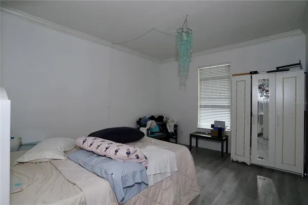 a bedroom with a bed and a chandelier