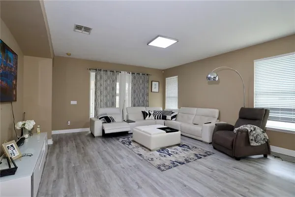 a living room with furniture and wooden floor