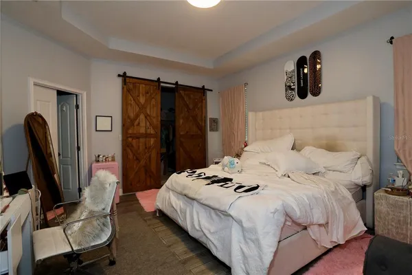 a bedroom with a bed a flat screen tv and dresser
