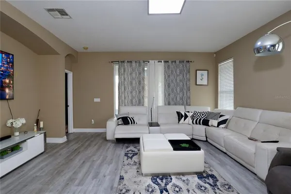 a living room with furniture and a wooden floor