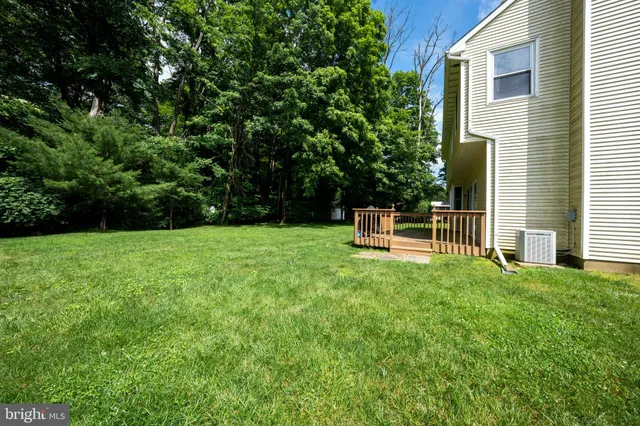 a view of a house with backyard and trees