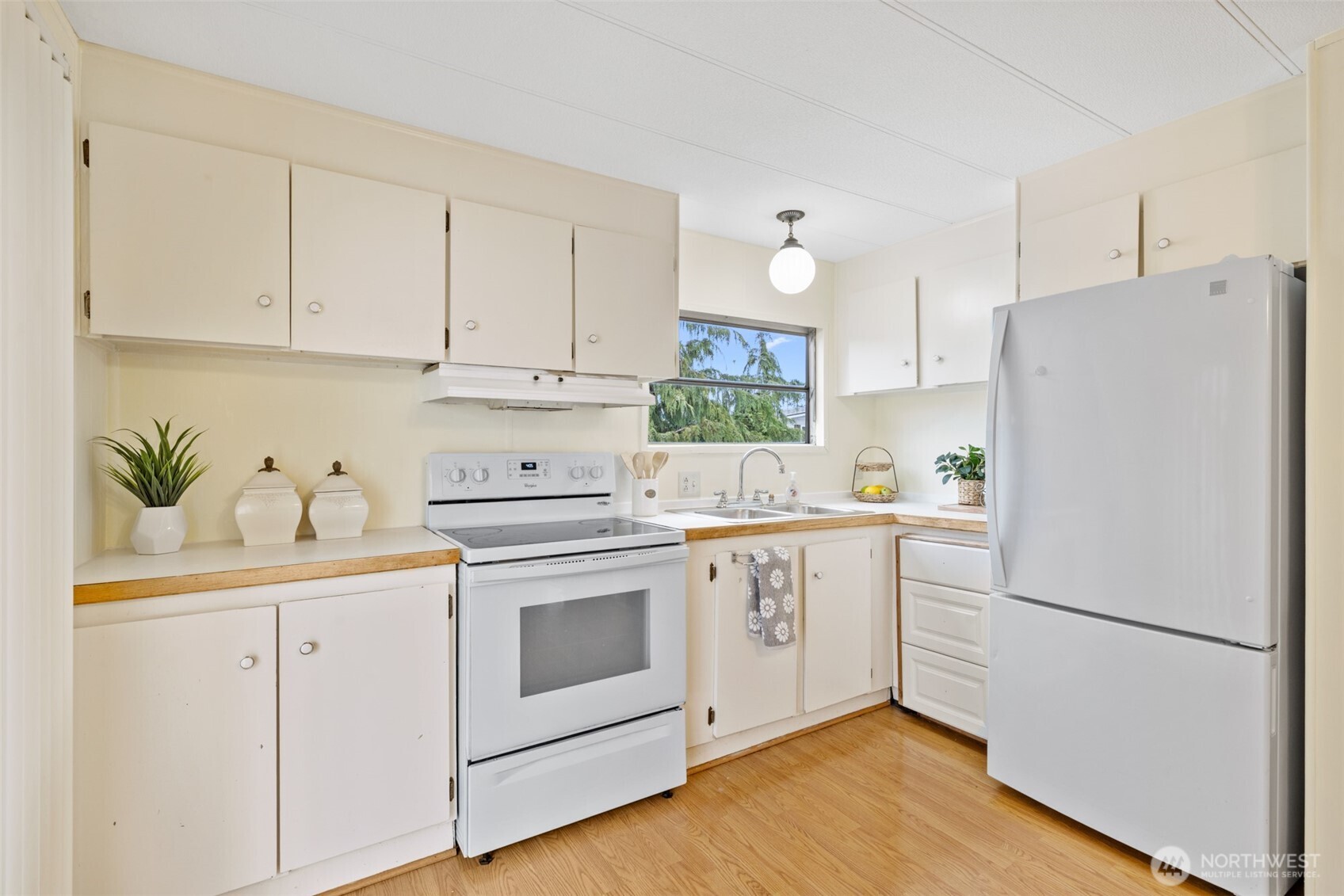 11 Juniper Mobile Estate Sequim, WA 98382 - Photo 13 of 31 a kitchen with white cabinets and white appliances