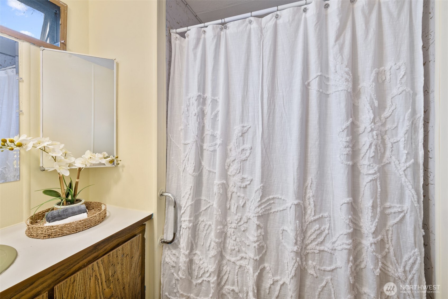 11 Juniper Mobile Estate Sequim, WA 98382 - Photo 20 of 31 a bathroom with a sink a mirror and a shower curtain