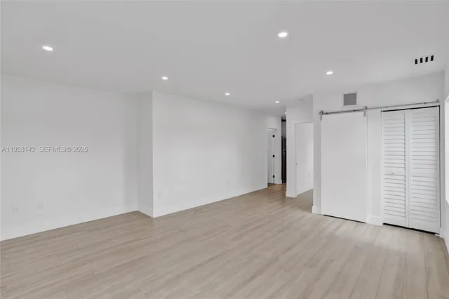 a view of an empty room with wooden floor