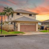 a view of yellow house with a yard and plants