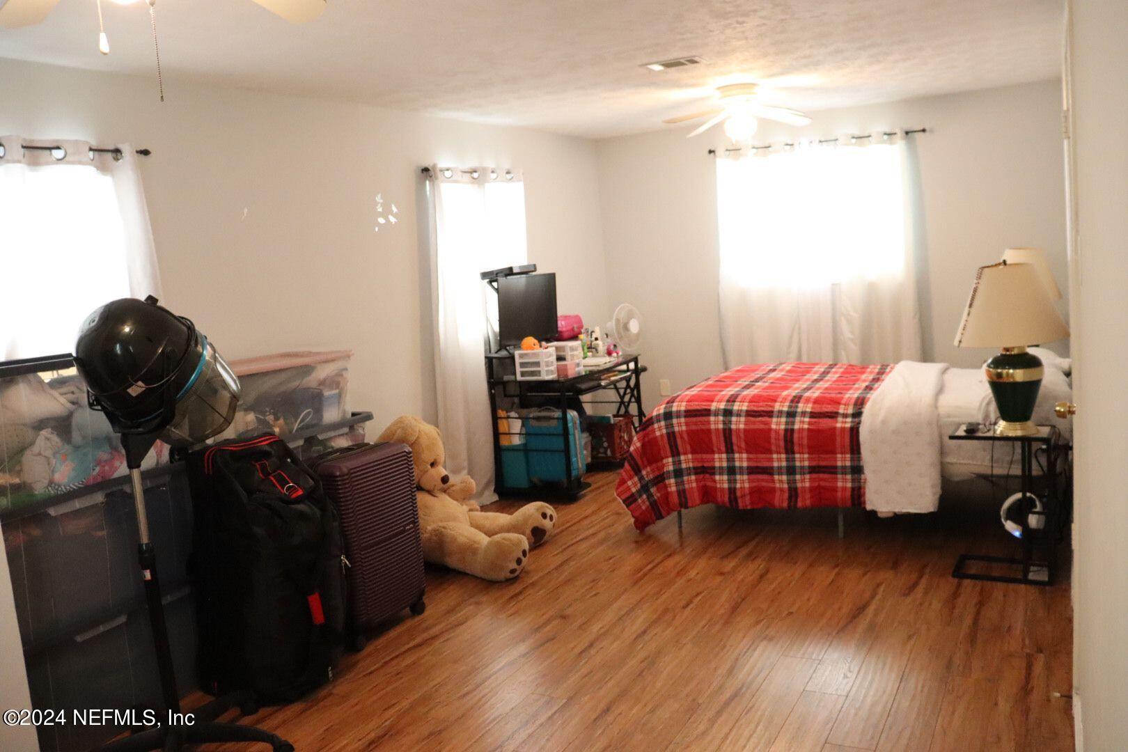 7351 Wheat Road Jacksonville, FL 32244 - Photo 11 of 15 a bedroom with a bed and wooden floor