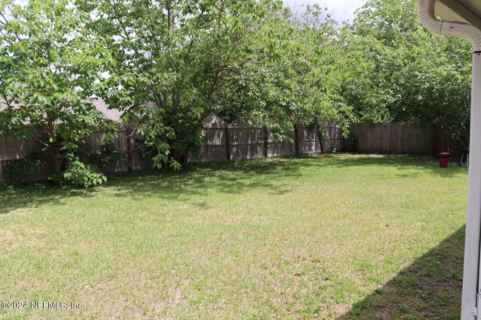 7351 Wheat Road Jacksonville, FL 32244 - Photo 13 of 15 a backyard of a house with lots of plants and large tree