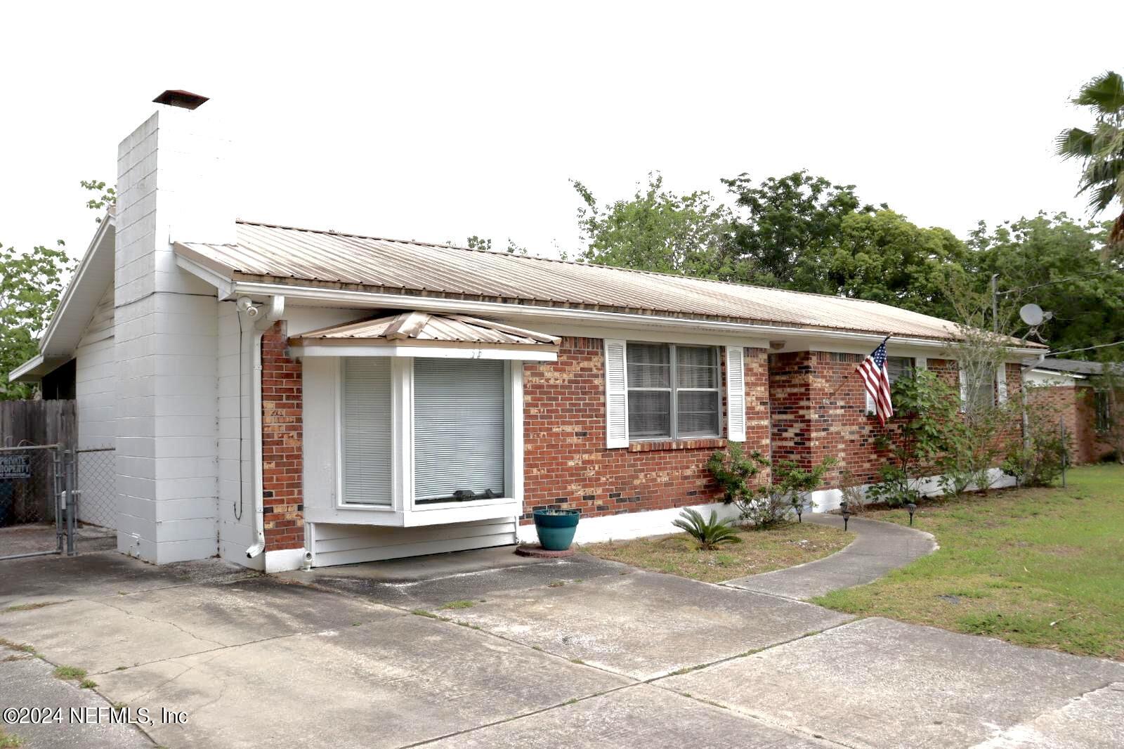7351 Wheat Road Jacksonville, FL 32244 - Photo 2 of 15 a front view of a house with a yard and outdoor seating