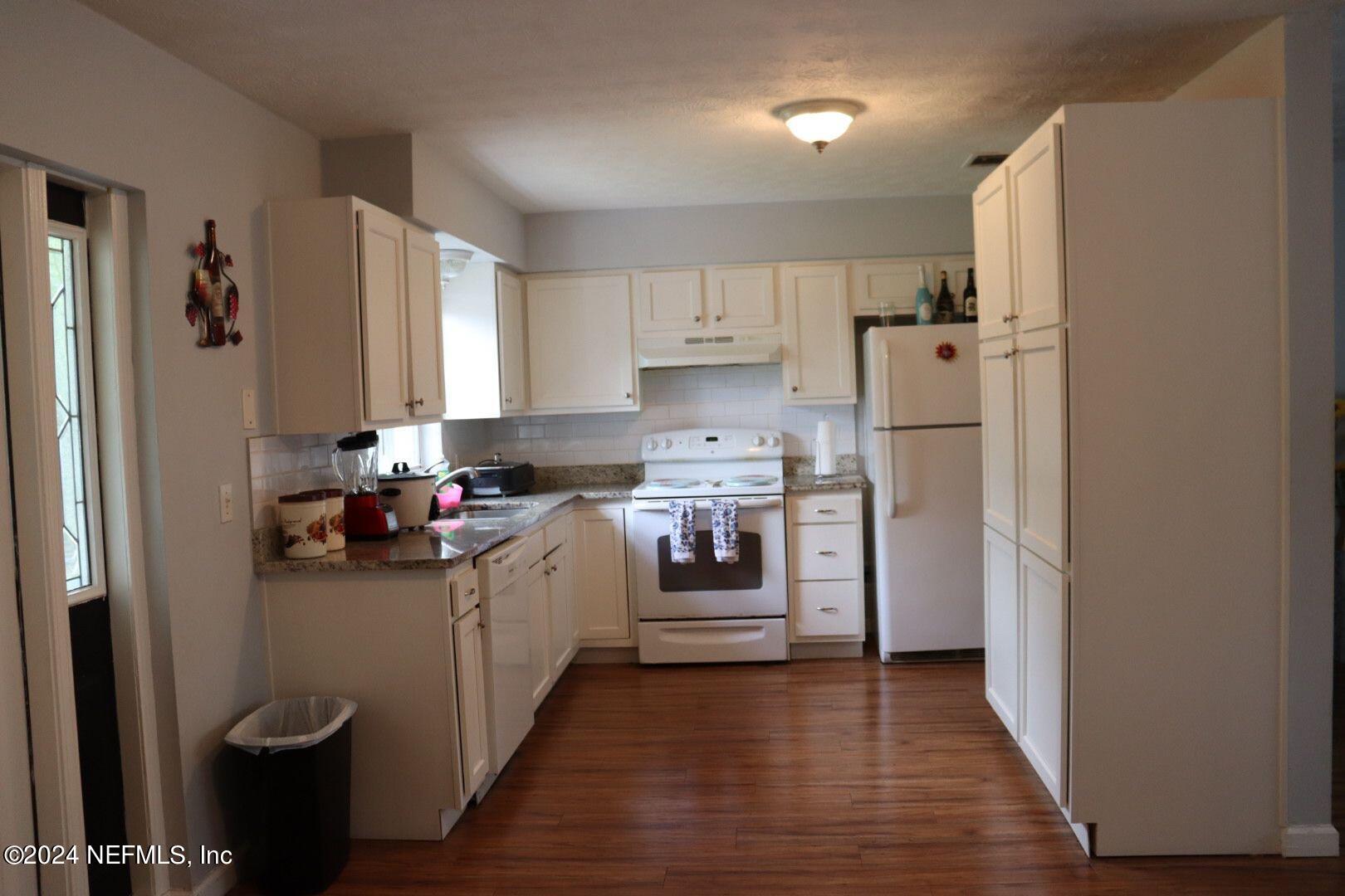 7351 Wheat Road Jacksonville, FL 32244 - Photo 6 of 15 a kitchen with a refrigerator a sink dishwasher and a stove with wooden floor