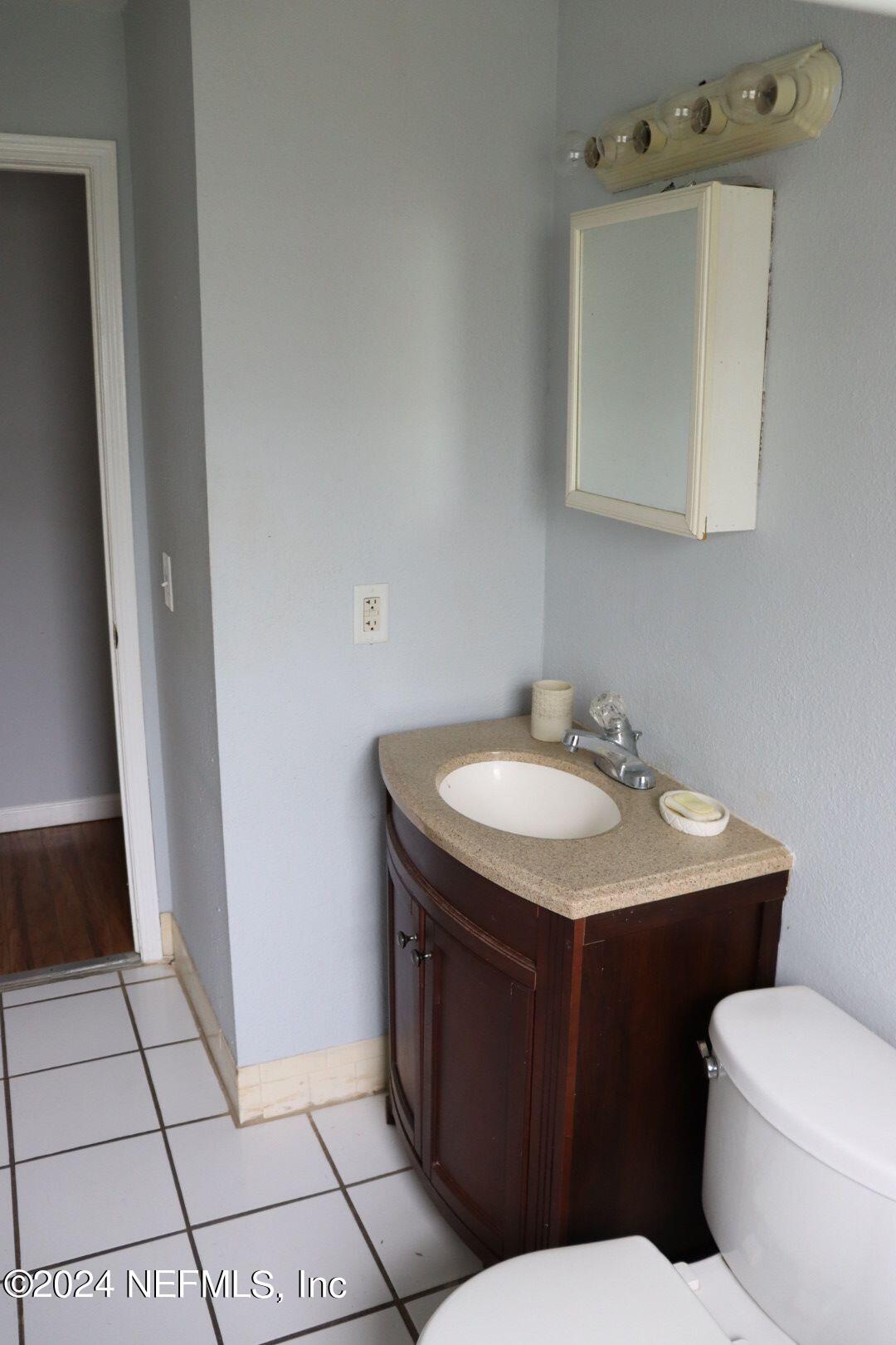 7351 Wheat Road Jacksonville, FL 32244 - Photo 7 of 15 a bathroom with a sink toilet and mirror