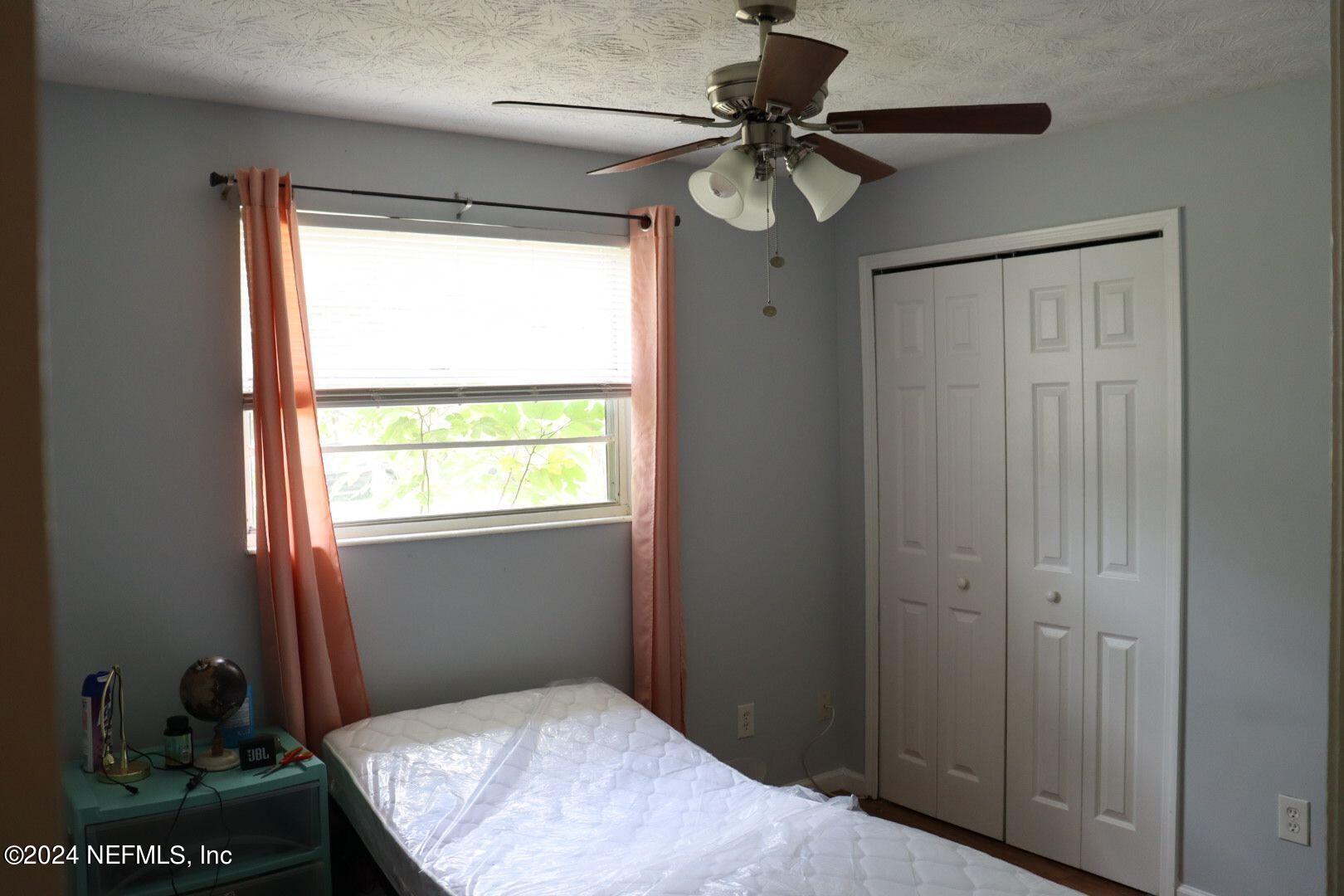 7351 Wheat Road Jacksonville, FL 32244 - Photo 10 of 15 a bedroom with a bed and a chandelier