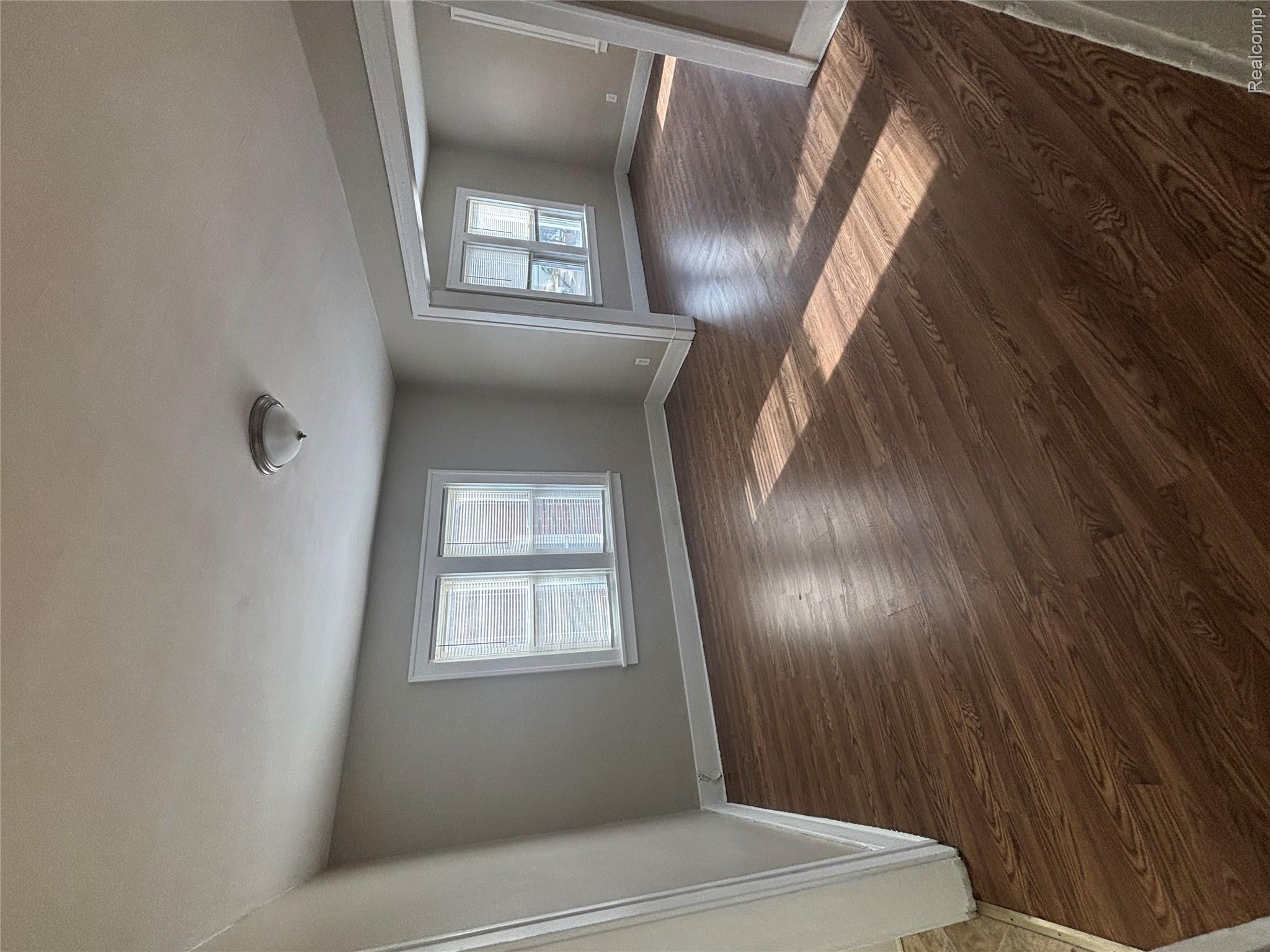 4740-4742 Alter Road Detroit, MI 48215 - Photo 18 of 20 Spacious living area featuring wood-finish flooring, light gray wall paint, and white trim