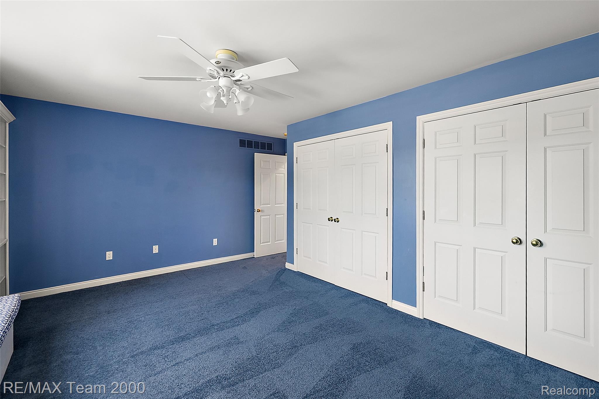 630 Sheldon Court Rochester, MI 48306 - Photo 61 of 94 Unfurnished bedroom featuring multiple closets, dark carpet, and a ceiling fan