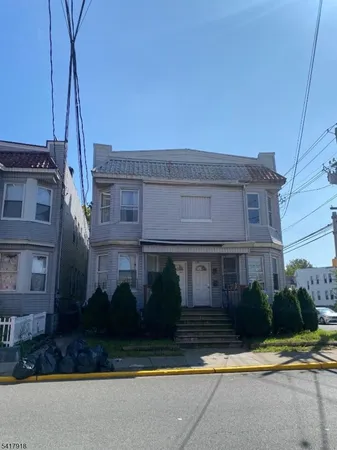 a view of a white house next to a yard