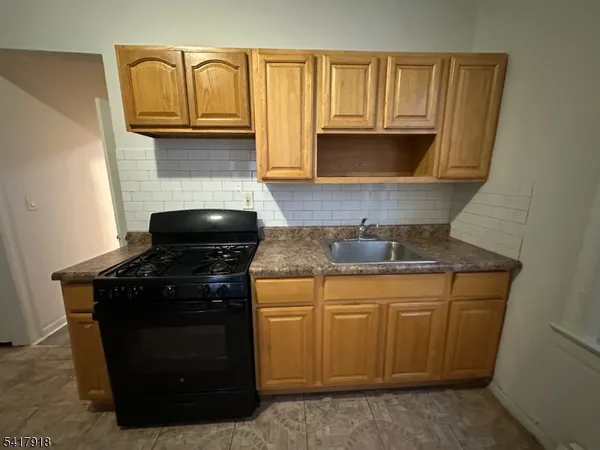 a kitchen with granite countertop cabinets stove top oven and microwave