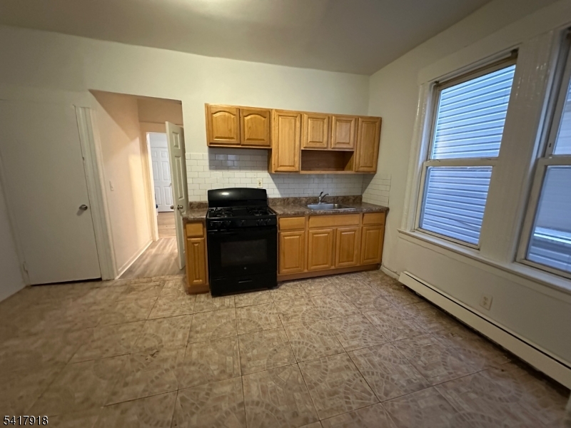 27 Pingry Place, Unit 1 Elizabeth, NJ 07208 - Photo 8 of 10 a kitchen with stainless steel appliances granite countertop a stove a sink and a refrigerator