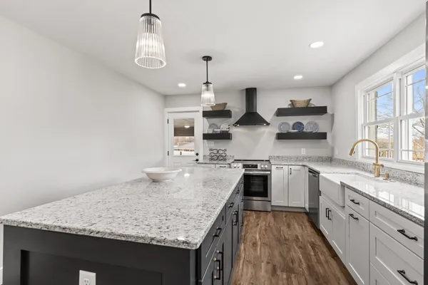 a kitchen with stainless steel appliances granite countertop a sink stove and refrigerator
