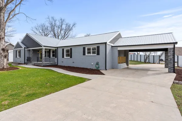 a front view of a house with a garden and yard