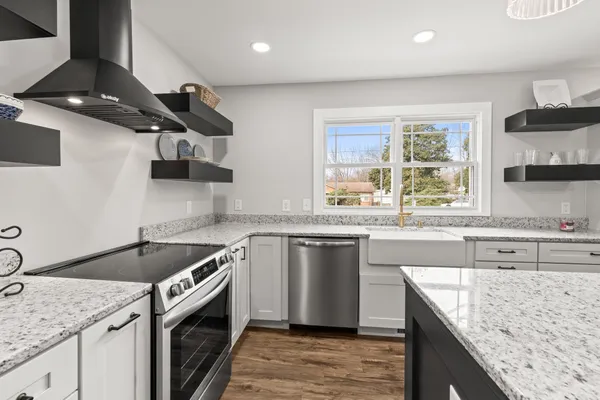a kitchen with stainless steel appliances granite countertop sink stove and refrigerator