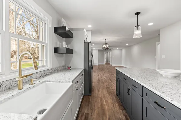 a kitchen with a sink stove and wooden floor