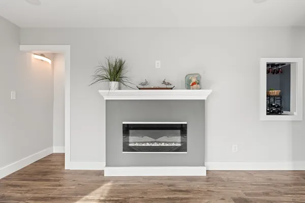 a living room with a fireplace and wooden floor