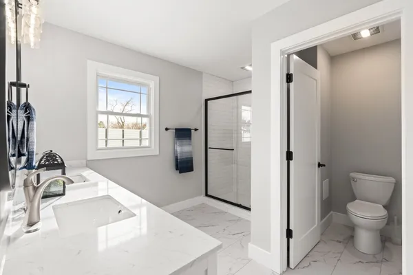 a bathroom with a granite countertop sink toilet and shower