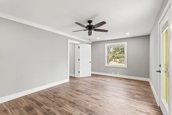 an empty room with wooden floor and windows