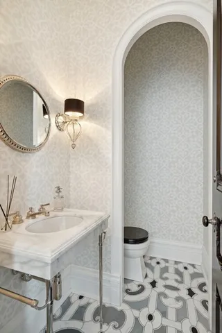 a bathroom with a sink a toilet and a mirror